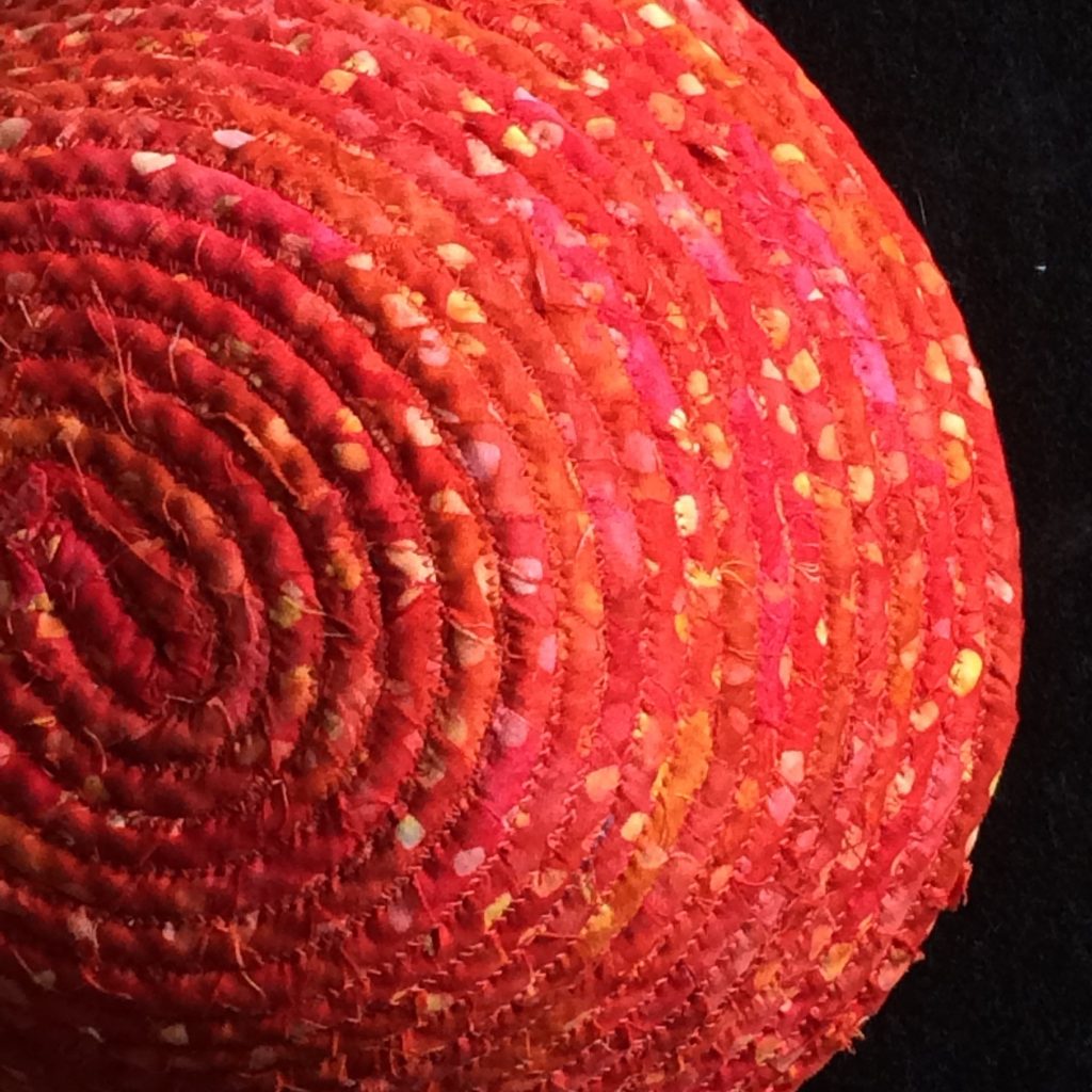 Red bowl made from fabric wrapped around rope and coiled together.