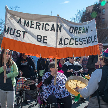 Protesters carry a banner saying, "the American Dream must be Accessible."