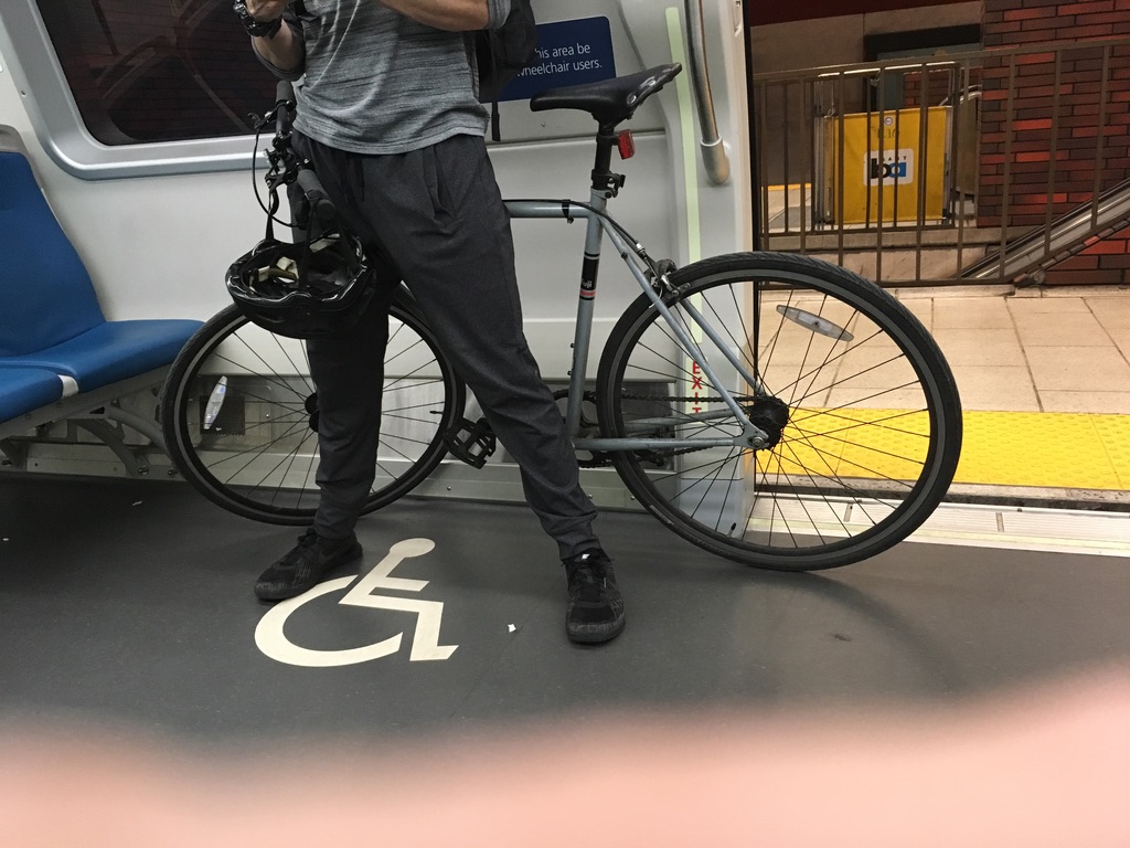 A person with a bike uses the wheelchair accessible spot on a BART train.