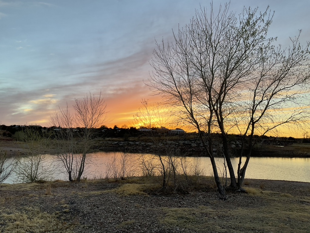 photo of narrow lake at sunset